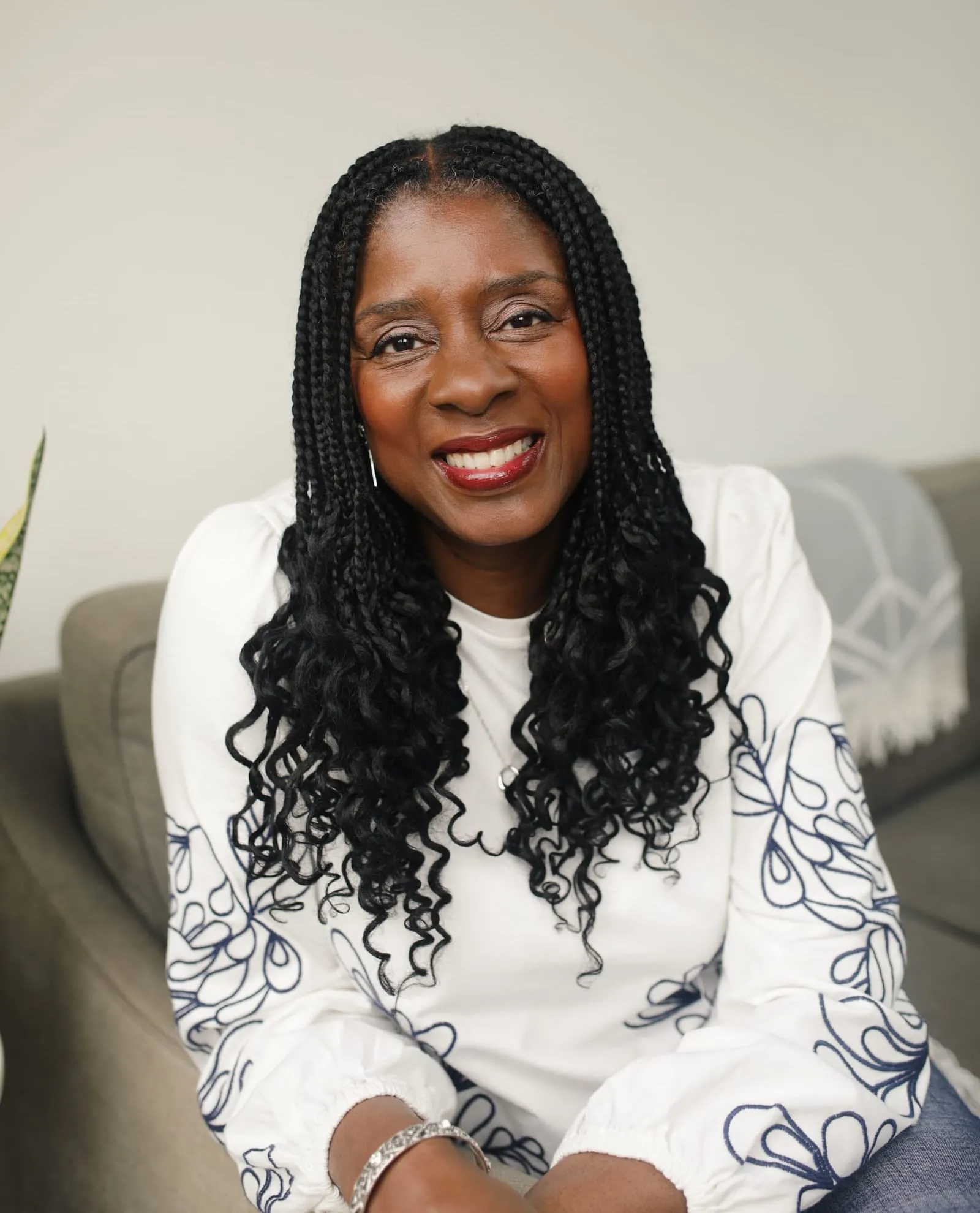 Lorraine Lee, smiling, seated in a light living room